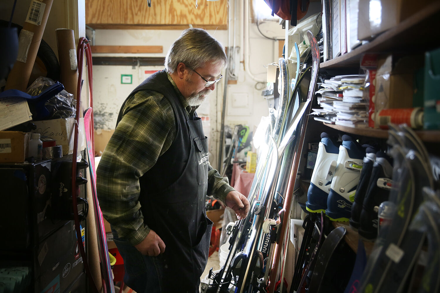 Luke Todd sorts through skis leaned up against the front wall